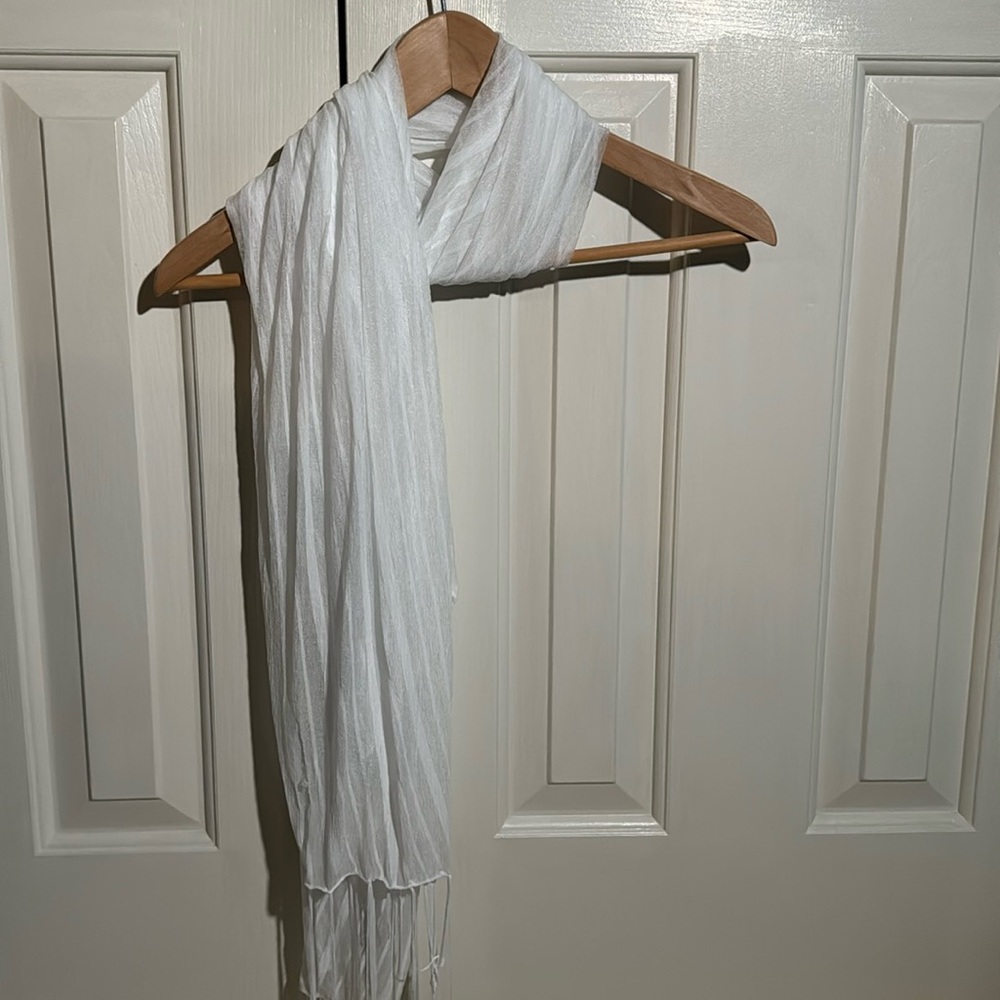 White scarf with tassels at ends.